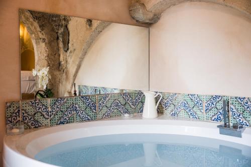 a bath tub in a bathroom with blue and white tiles at Villa Le Murelle in Tramonti