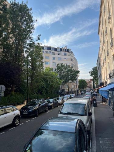 een rij auto's geparkeerd in een stadsstraat bij Super appartement refait à neuf beaucoup de charme in Boulogne-Billancourt