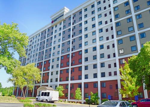 a white van parked in front of a large building at Candlewood Suites Indianapolis Downtown Medical District by IHG in Indianapolis