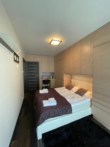 a bedroom with a large bed in a room at Cappuccino by OneApartments in Jurata