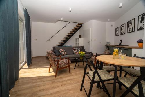 - un salon avec une table et des chaises ainsi qu'un escalier dans l'établissement Domek w Antoninie, à Antonin