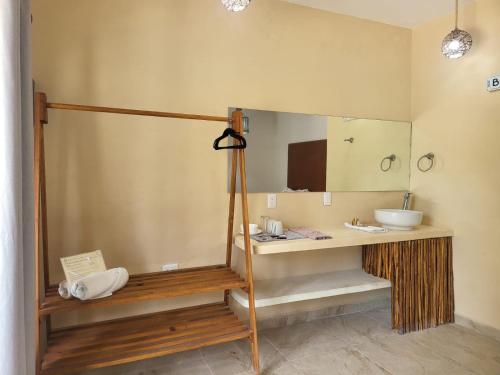 La salle de bains est pourvue d'un lavabo et d'un miroir. dans l'établissement Suites Villas el Jardín, à Holbox