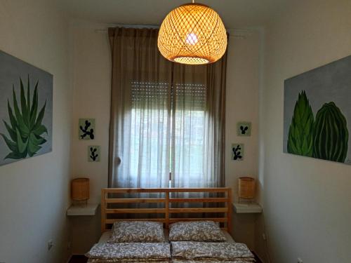 a bedroom with a bed and a chandelier at Studio apartman Cactus in Zagreb