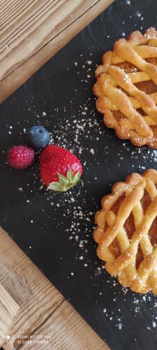 een zwart bord met wafels, aardbeien en bosbessen bij Atelier della Montagna in Zambla Alta