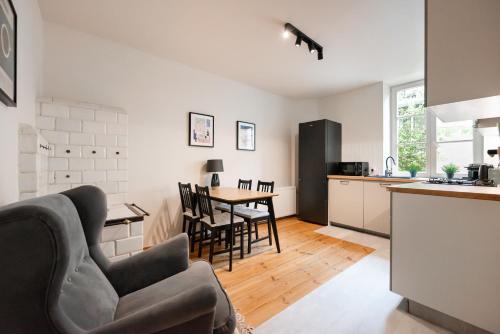 een keuken en een woonkamer met een tafel en stoelen bij Park Promenada Brown Apartment in Warschau