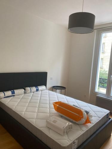 un lit avec un objet orange au-dessus dans l'établissement Super appartement refait à neuf beaucoup de charme, à Boulogne-Billancourt