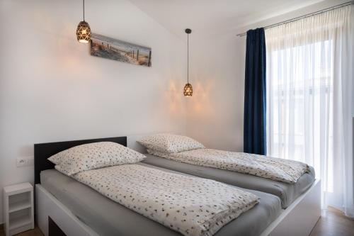 two twin beds in a room with a window at Morski Apartament in Sarbinowo