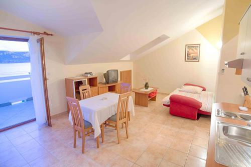 a kitchen and living room with a table and chairs at Arka in Stara Novalja