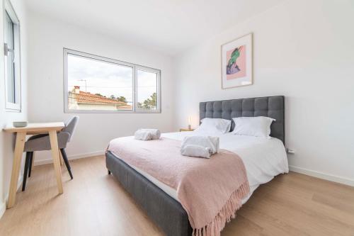 ein Schlafzimmer mit Bett, Schreibtisch und Fenster in der Unterkunft Villa Kamila in Aroeira