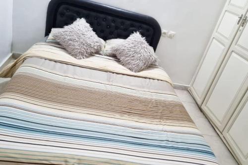 a bed with two fuzzy pillows on top of it at Maison l'océan in Rabat