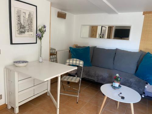 un salon avec un canapé bleu et une table dans l'établissement GuestHouse Du Moulin (logement neuf), à Saint-Cyr-sur-Mer