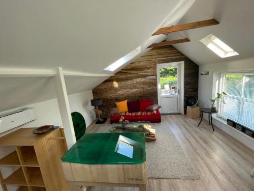 B&B Unieks في Nietap: غرفة معيشة مع أريكة حمراء وطاولة