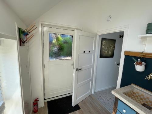 a kitchen with a white door and a window at B&B Unieks in Nietap