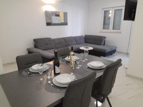 a dining room table with chairs and a couch at Lavanda Apartments in Sveti Petar