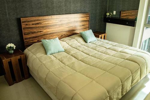 a large bed with two pillows on it in a bedroom at Lovely Apartment with Rooftop, Pool & Gym in CDMX in Mexico City