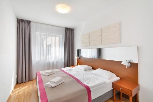 a bedroom with a bed with two towels on it at Atrium Oaza Sarbinowo in Sarbinowo