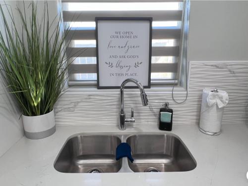 a sink in a kitchen with a sign above it at Luxurious Modern Apartment #4 in Edinburg