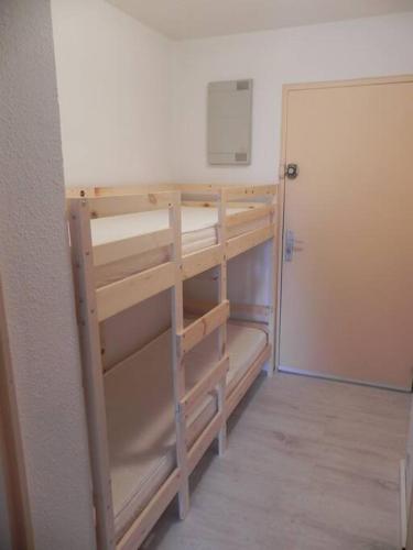 Cette chambre dispose d'étagères en bois et d'une porte. dans l'établissement Magnifique studio avec loggia, au Grau-du-Roi