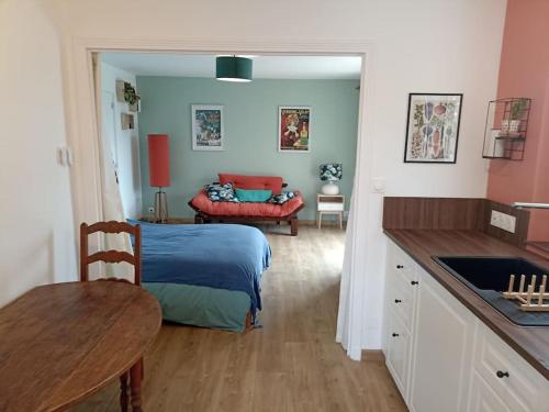 um quarto com uma cama e uma mesa num quarto em Studio chemin de Saint Jacques em Vals-près-le-Puy