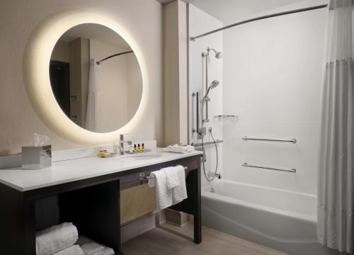 uma casa de banho com um lavatório, um espelho e um chuveiro em Best Western Plus Executive Residency Jackson Northeast em Jackson