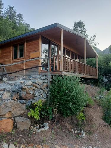 a log cabin with a stone wall at Hergül Holiday Village in Gazipasa