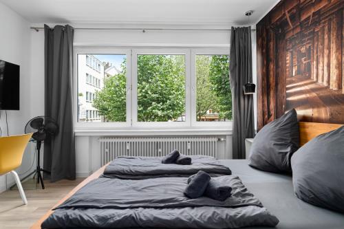 亞琛的住宿－Apartment 3, direkt am Bahnhof，卧室内的一张床铺,设有大窗户