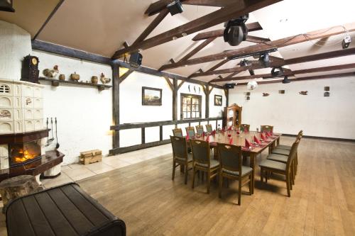 a dining room with a table and chairs and a fireplace at Hotel Niedźwiadek in Wdzydze Kiszewskie