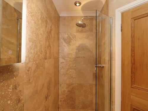 a bathroom with a shower with a glass door at North Lodge in Annan