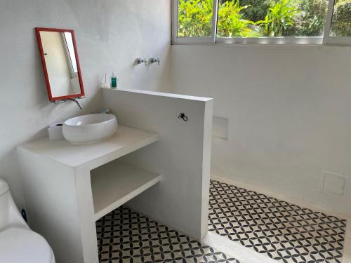 a white bathroom with a sink and a mirror at La Casa de la Montaña in La Vega