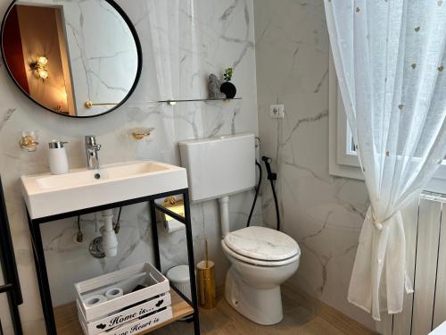 een badkamer met een toilet, een wastafel en een spiegel bij House of artist in Isolabona