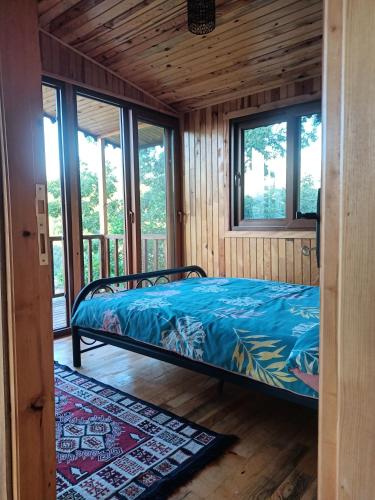 a bedroom with a bed in a room with windows at Hergül Holiday Village in Gazipasa