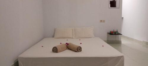 a bed with two rolled up towels on it at Mango Homestay in Sekotong