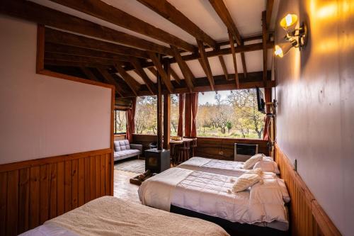 sypialnia z 2 łóżkami i oknem w obiekcie Cabañas Borde Rio Las Trancas w mieście Nevados de Chillan