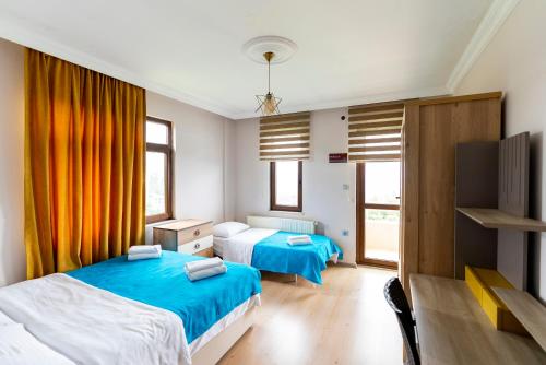 a bedroom with two beds and a tv at Hill House in Trabzon
