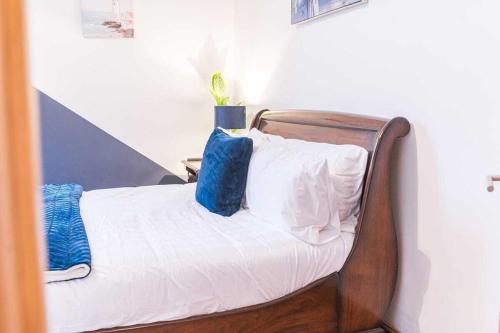 a bed with white sheets and blue pillows at WhereToStay Cosy 3bed House in Barrow in Furness