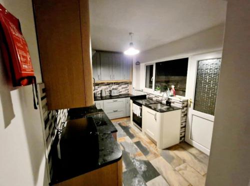 a kitchen with white cabinets and a counter top at WhereToStay Cosy 3bed House in Barrow in Furness