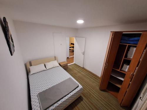 Cette petite chambre comprend un lit et une armoire. dans l'établissement apartman ANAMI, à Bar