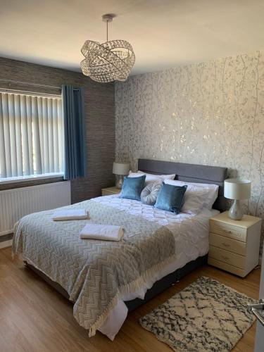 a bedroom with a large bed with two towels on it at Hafan Traeth in Prestatyn