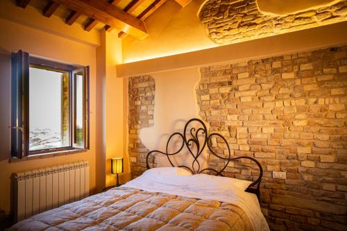 a bed in a room with a brick wall at La torre tra terra e cielo in Petritoli