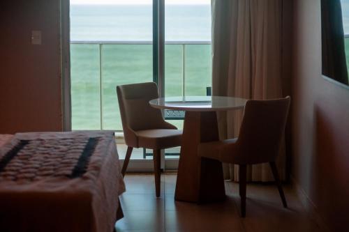 a room with a table and two chairs and a window at Paradiso Macae Hotel in Macaé