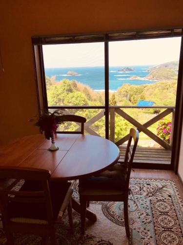 a table and chairs in a room with a large window at Marine View Shimane - Vacation STAY 78823v in Matsue
