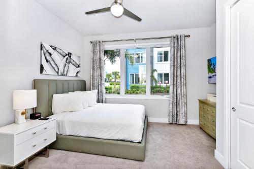 ein weißes Schlafzimmer mit einem Bett und einem Fenster in der Unterkunft Relaxing Condo With Resort Amenities near Disney - B49 #115 in Kissimmee