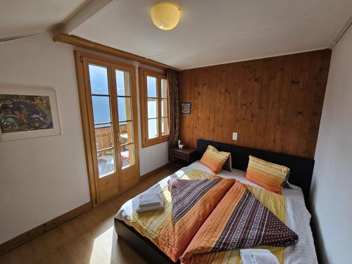 a bedroom with two beds and a large window at Chalet Aargovia South in Wengen