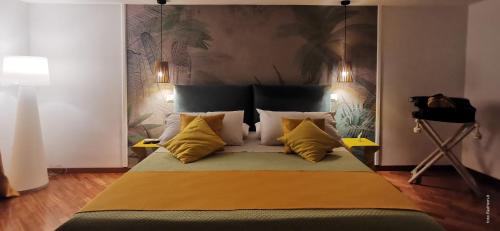 a bedroom with a large bed with yellow pillows at Two Rooms Chiaia 37 in Naples