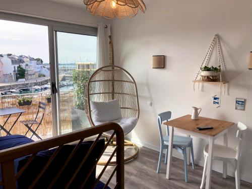 Zimmer mit einem Tisch, Stühlen und einem Fenster in der Unterkunft Studio du vieux port in Quiberon