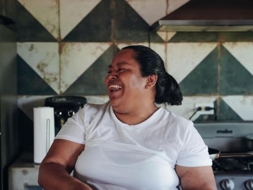 a pregnant woman is laughing in a kitchen at Hostel-Island Paradise, Saboga Lodge and Villa Noelia in Panama City