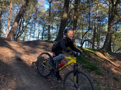 ein kleines Kind, das auf einer unbefestigten Straße Fahrrad fährt in der Unterkunft PRIVÉ IN EEN BOSRIJKE OMGEVING Welkom bij gastenverblijf het ontsnapte schaap in Jubbega in Jubbega-Schurega