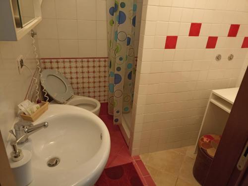 een badkamer met een witte wastafel en een toilet bij Central GH Formia in Formia