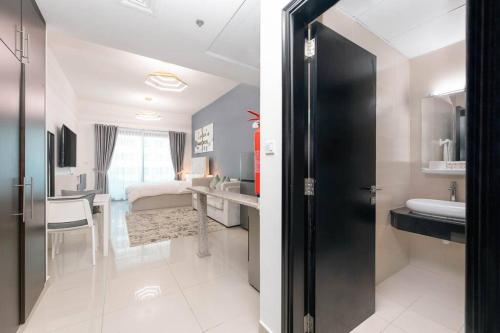 um quarto com uma casa de banho com um lavatório e uma cama em Urban Caves - Stylish Condo Near Marina Walk With City Views em Dubai