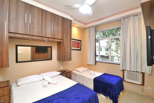 a hotel room with two beds and a tv at Rio Spot Homes Copacabana D038 in Rio de Janeiro